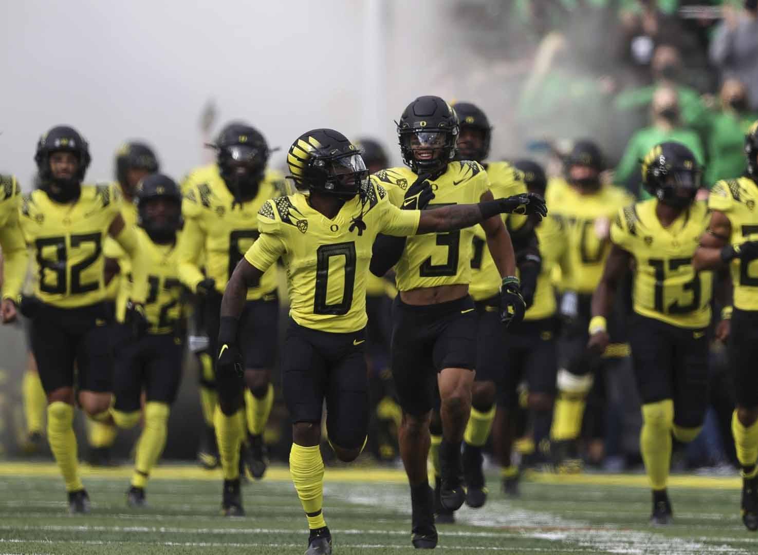 Oregon football players take the field