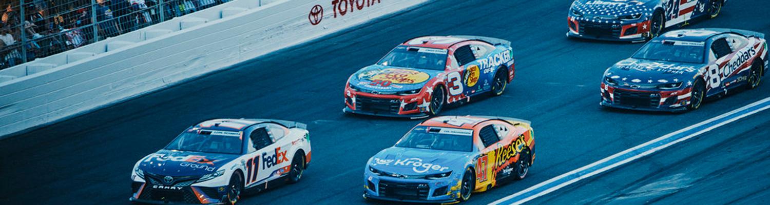 A pack of racecars on the high banks of Charlotte Motor Speedway during the 2022 Coca-Cola 600.